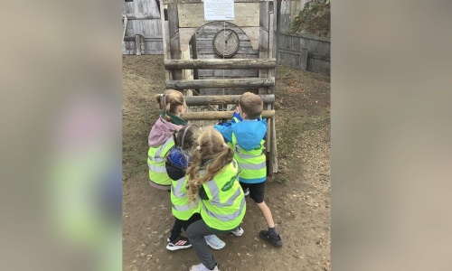 Year 2 pupils exploring a wooden gate at Stansted Mountfitchet Castle
