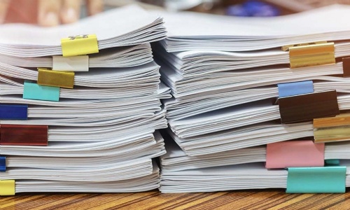 Stacks of school policy documents marked with coloured tabs