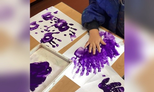 Purple handprint painting by a Reception child